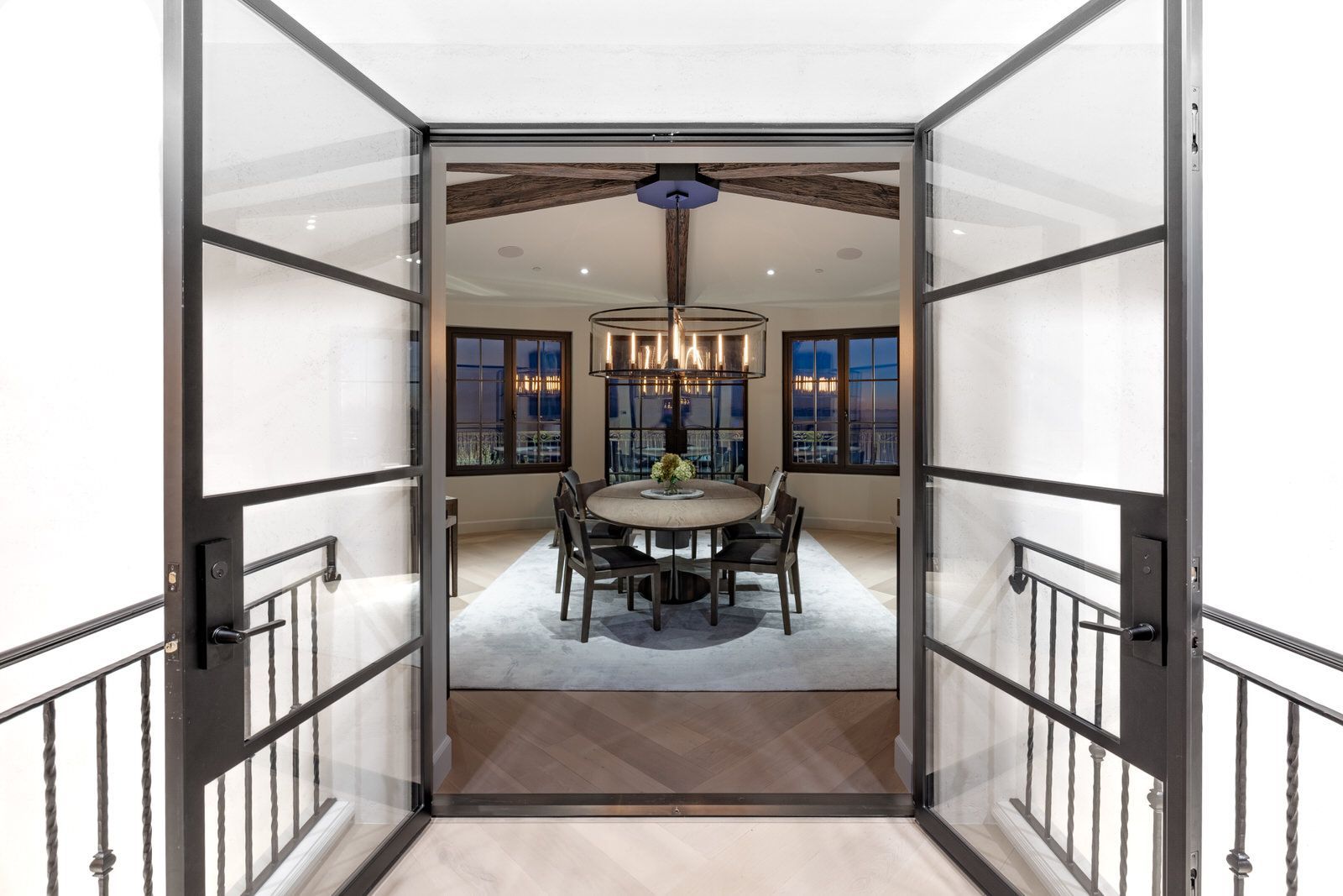 A dining room with a table and chairs and a chandelier.