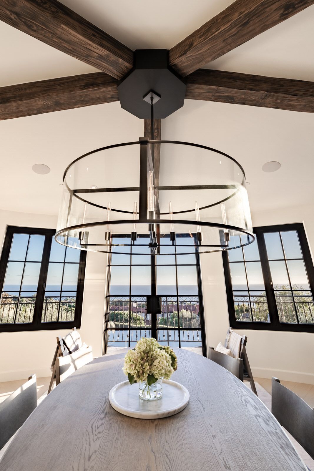 A dining room table with a vase of flowers on it