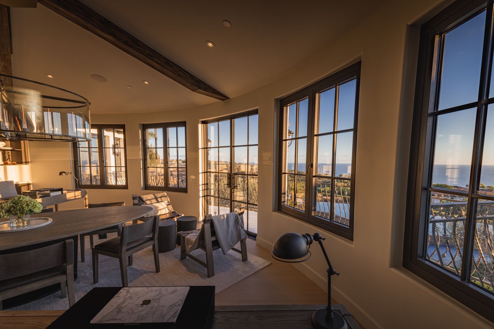 A living room with a table and chairs and a lot of windows.