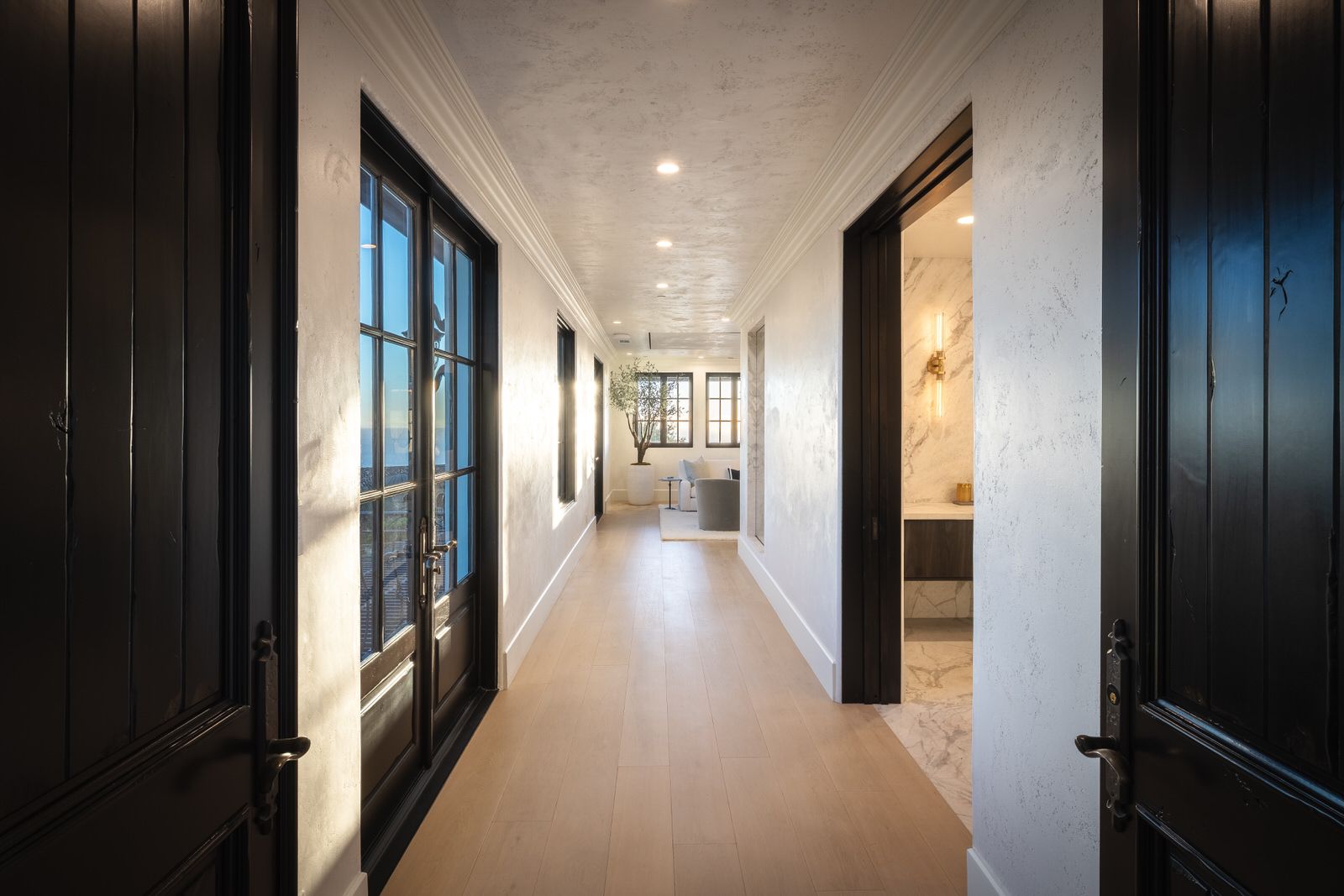 A long hallway with sliding glass doors leading to a bathroom.