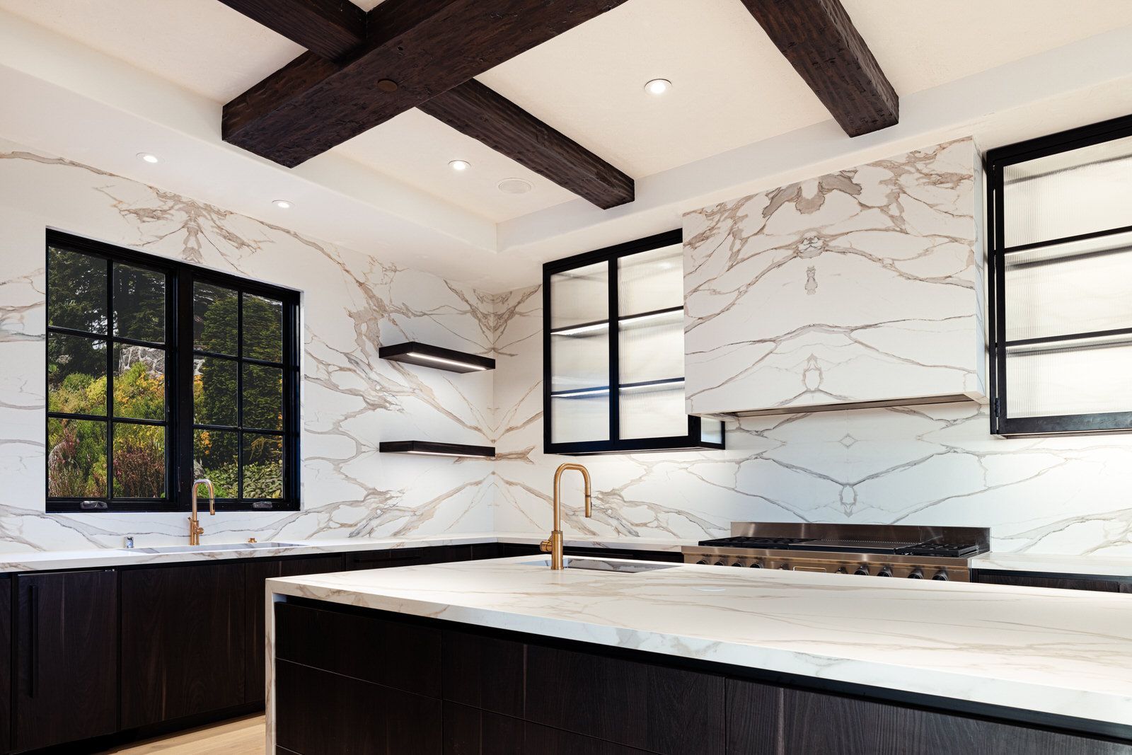 A kitchen with marble counter tops , wooden cabinets , and a large island.