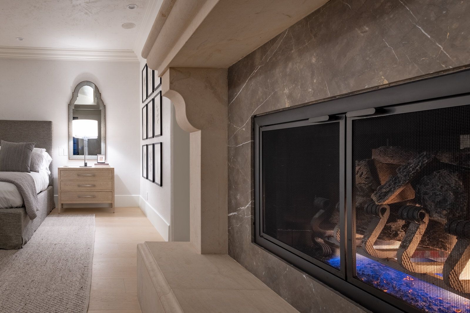 A bedroom with a fireplace and a bed.