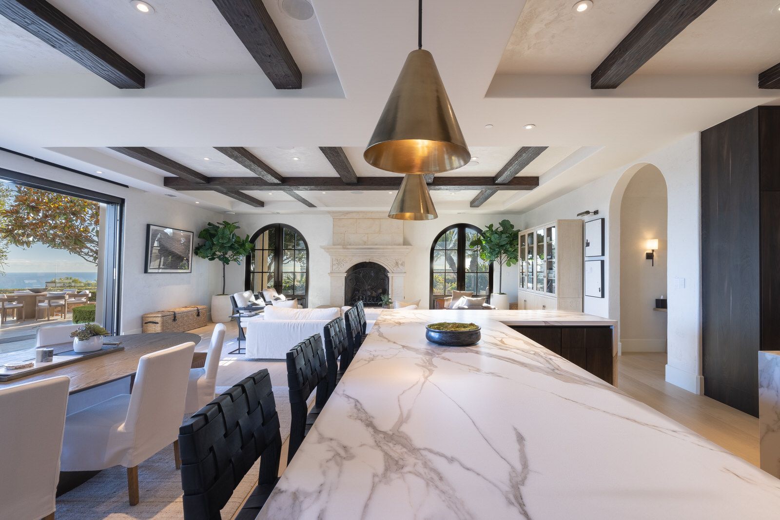 A large kitchen with a marble counter top and a fireplace.