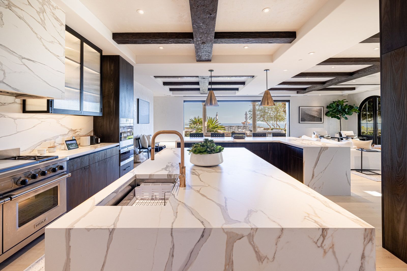 A kitchen with a large island and marble counter tops.