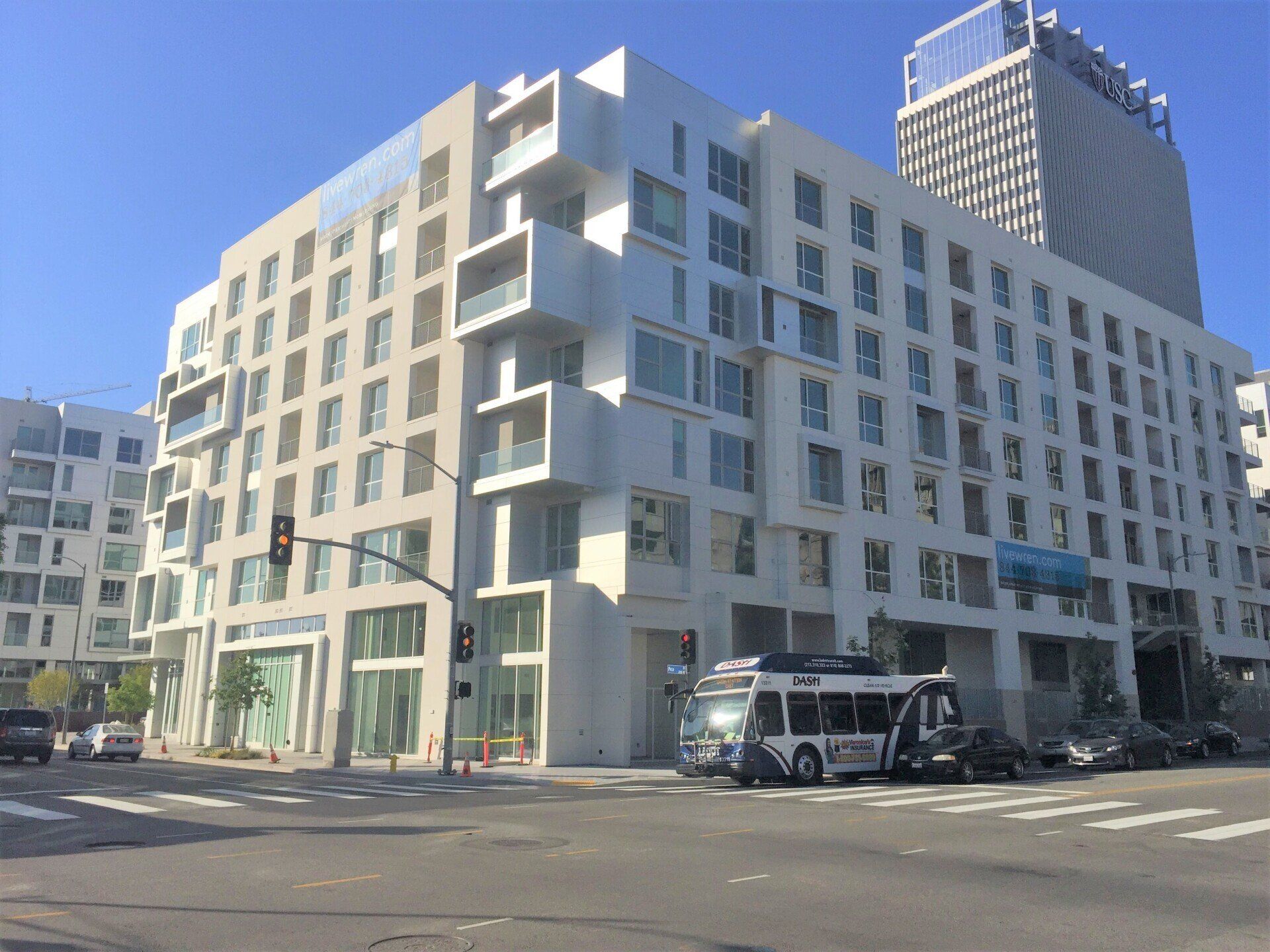 A large white building with a bus parked in front of it.