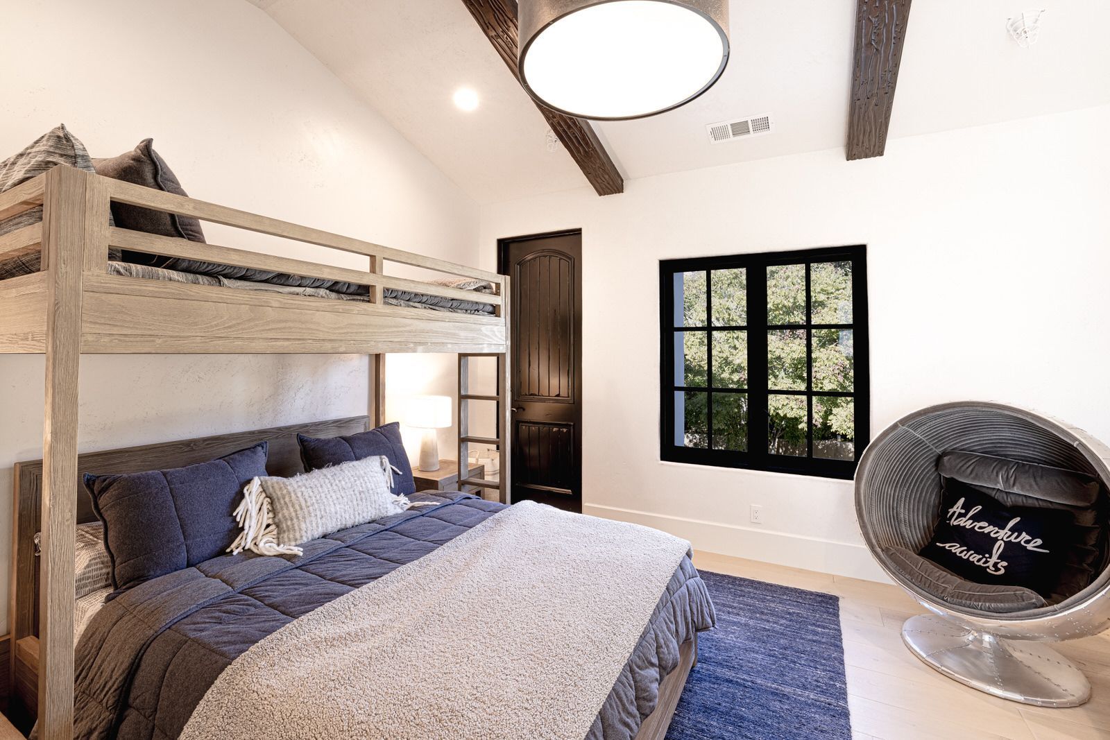 A bedroom with a bunk bed and a chair.