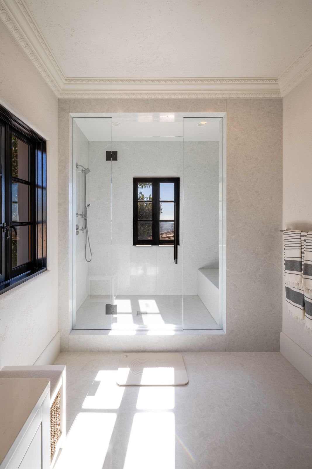 A bathroom with a walk in shower and a window.