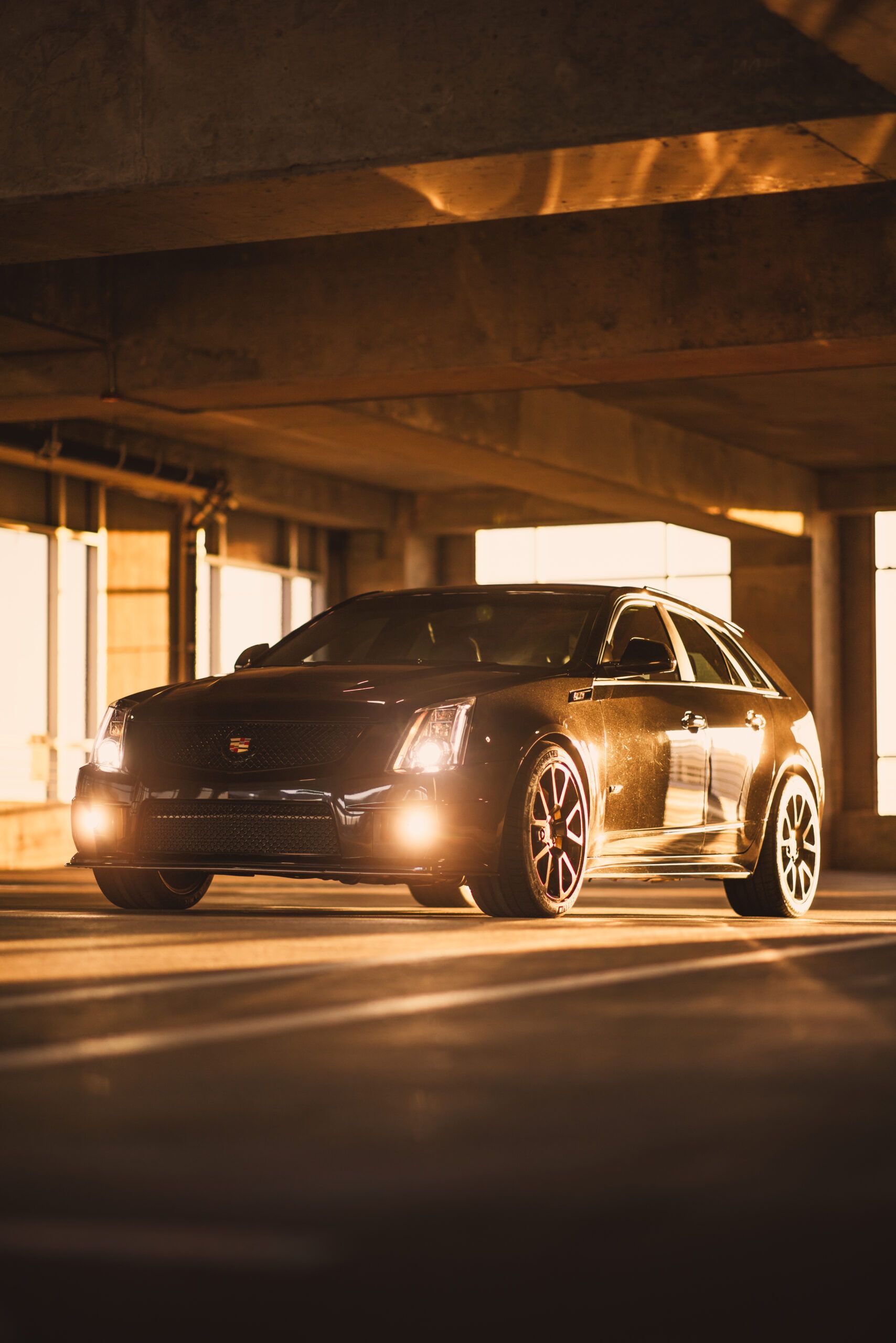 Two people, wearing matching black shirts, smile and stand in a room decorated with balloons.