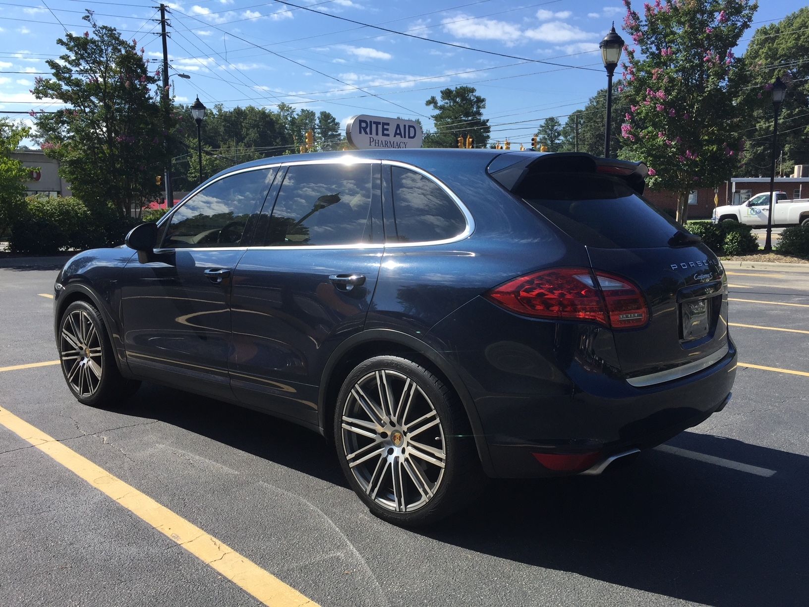 A dark blue Porsche Cayenne SUV parked in an outdoor lot on a sunny day.