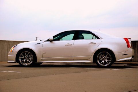 A white Cadillac CTS-V sedan parked on an outdoor concrete level during a bright, overcast day.