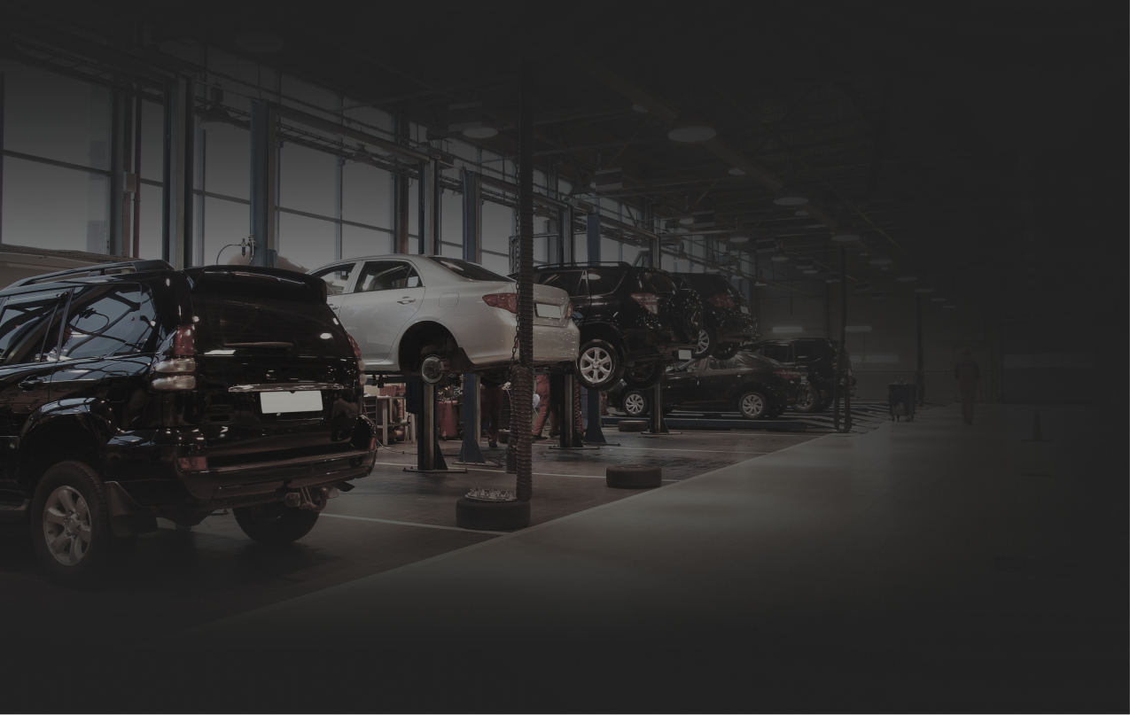 Cars being worked on inside an auto repair shop.