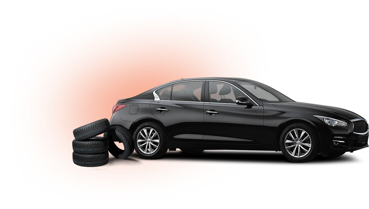 Black sedan with tires stacked in front.
