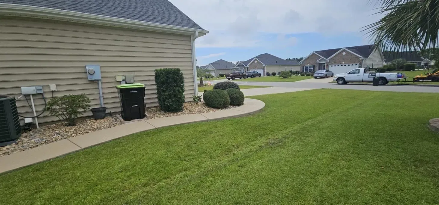 Residential neighborhood with a house, green lawn, and street.