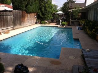 A large swimming pool with a wooden fence surrounding it
