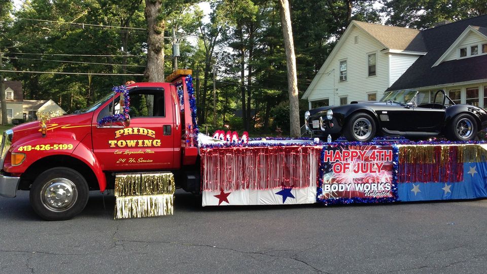 24-hour Towing Services — Truck Towing A Sports Car in A Parade in East Longmeadow, MA