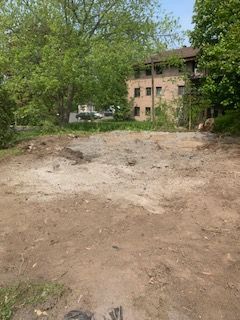 Un grand champ de terre avec un bâtiment en arrière-plan.