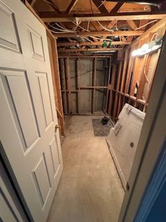 Une pièce avec une porte et une laveuse et une sécheuse à l'intérieur.