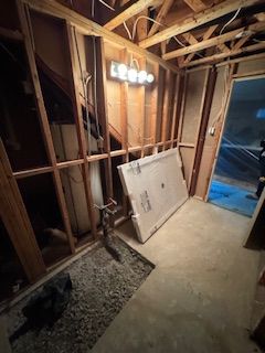 Une pièce dans une maison en construction avec un grand morceau de bois sur le sol.