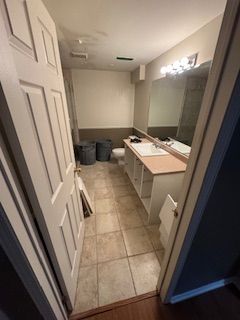 Une salle de bain avec deux lavabos, un WC et un miroir.