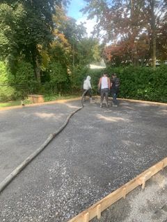Un groupe de personnes travaille sur une allée en béton.
