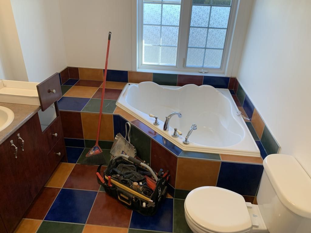 Une salle de bain avec baignoire jacuzzi, WC et lavabo.