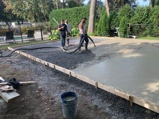 Un groupe d'hommes travaille sur une allée en béton.