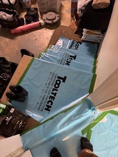 Une personne se tient debout sur un escalier recouvert de sacs en plastique.