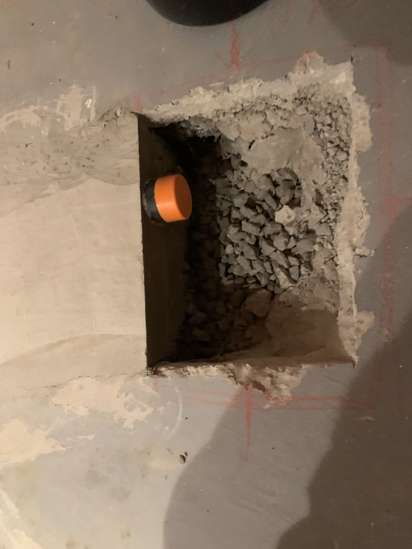 Un trou dans le mur avec un tuyau qui en sort.