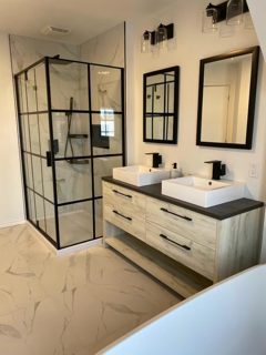 Une salle de bain avec deux lavabos et une douche à l'italienne