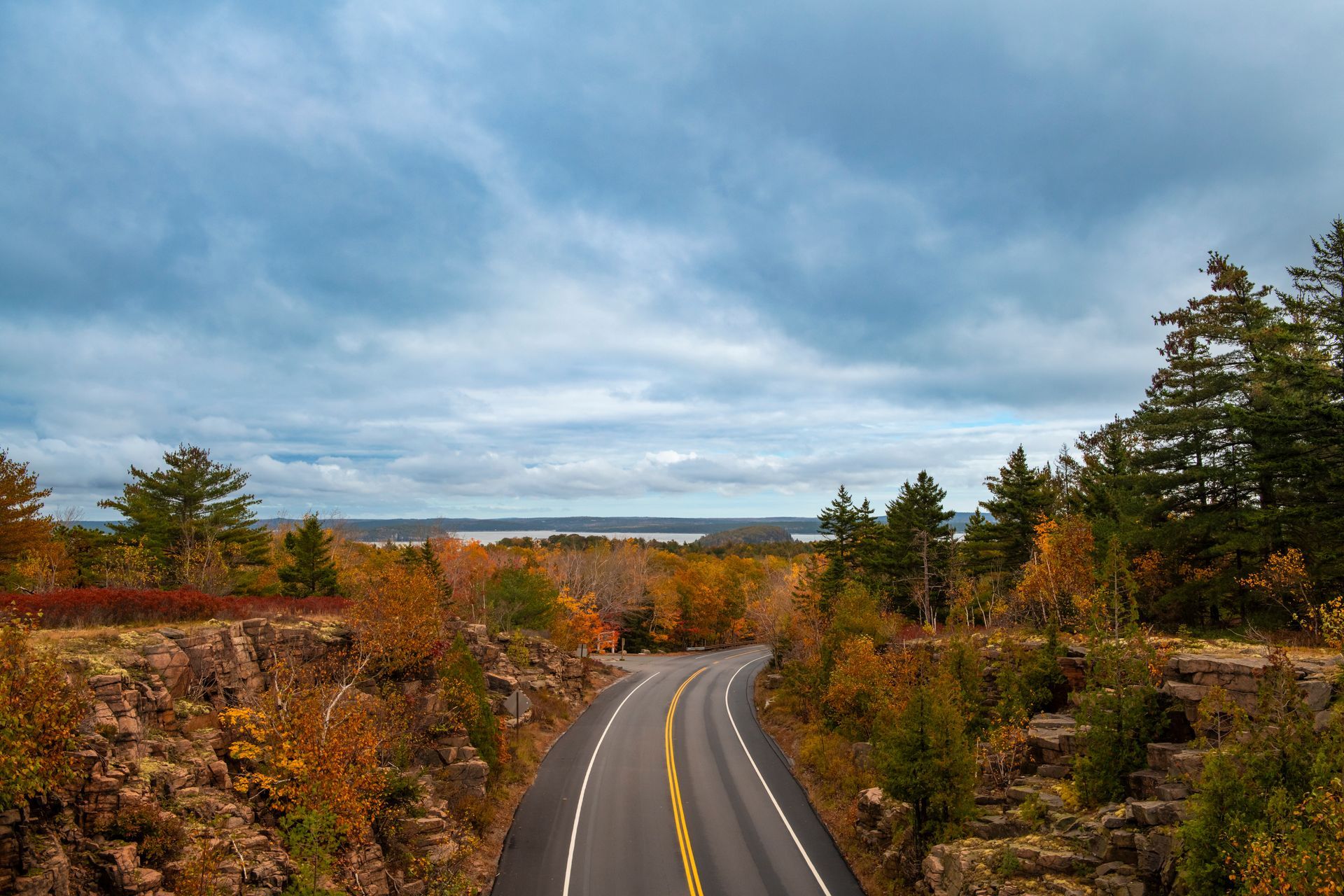 A road going through a valley surrounded by trees and rocks.