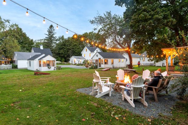 Travelers enjoying a fire pit overlooking a cottage property