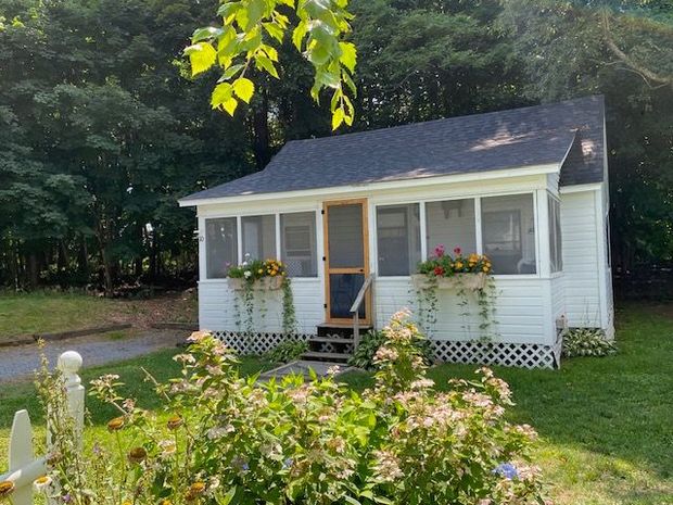 A small white house with a picnic table in front of it