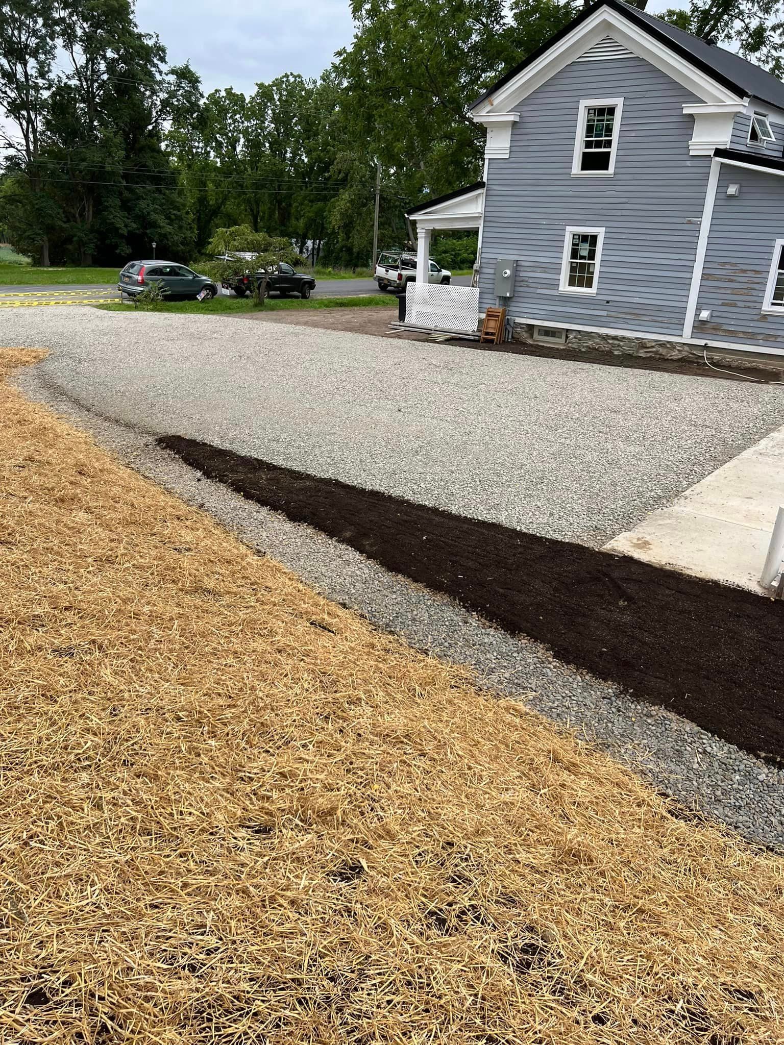 A house with a gravel driveway in front of it.