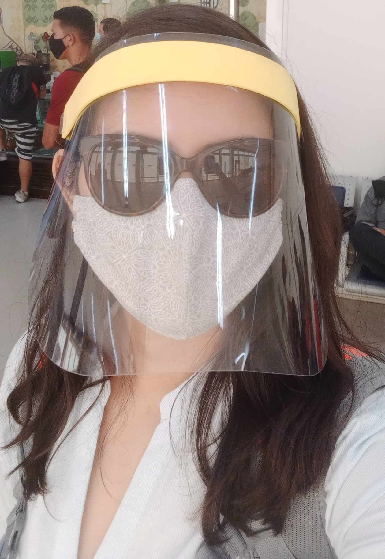 Larissa Bona usando uma máscara e um face shield