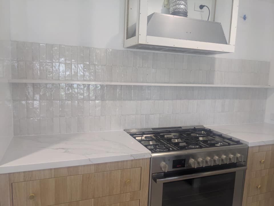A Kitchen With a Stove , Oven , and Hood — ASpect Wall & Floor Tiling in Charmhaven, NSW