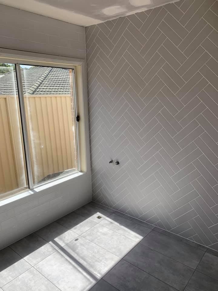 A Room With a Window and a Herringbone Tile Wall — ASpect Wall & Floor Tiling in Tuncurry, NSW