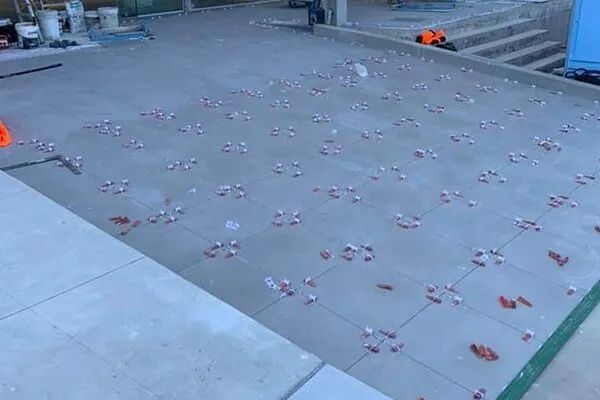 A Concrete Floor With a Lot of Tiles on It — ASpect Wall & Floor Tiling in Charmhaven, NSW