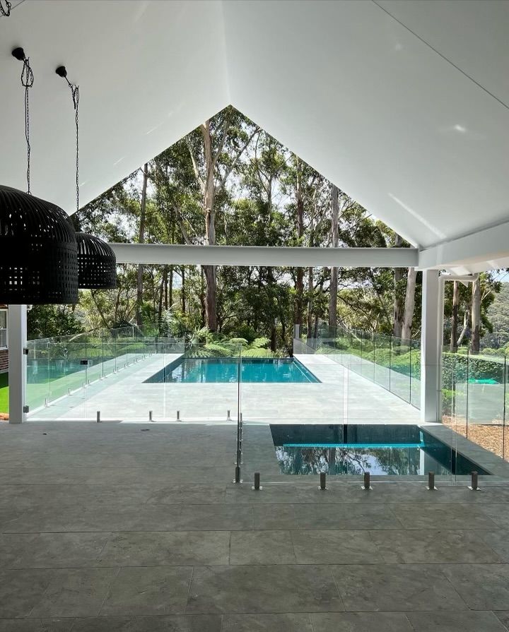 A House With a Large Swimming Pool in Front of It — ASpect Wall & Floor Tiling in Charmhaven, NSW