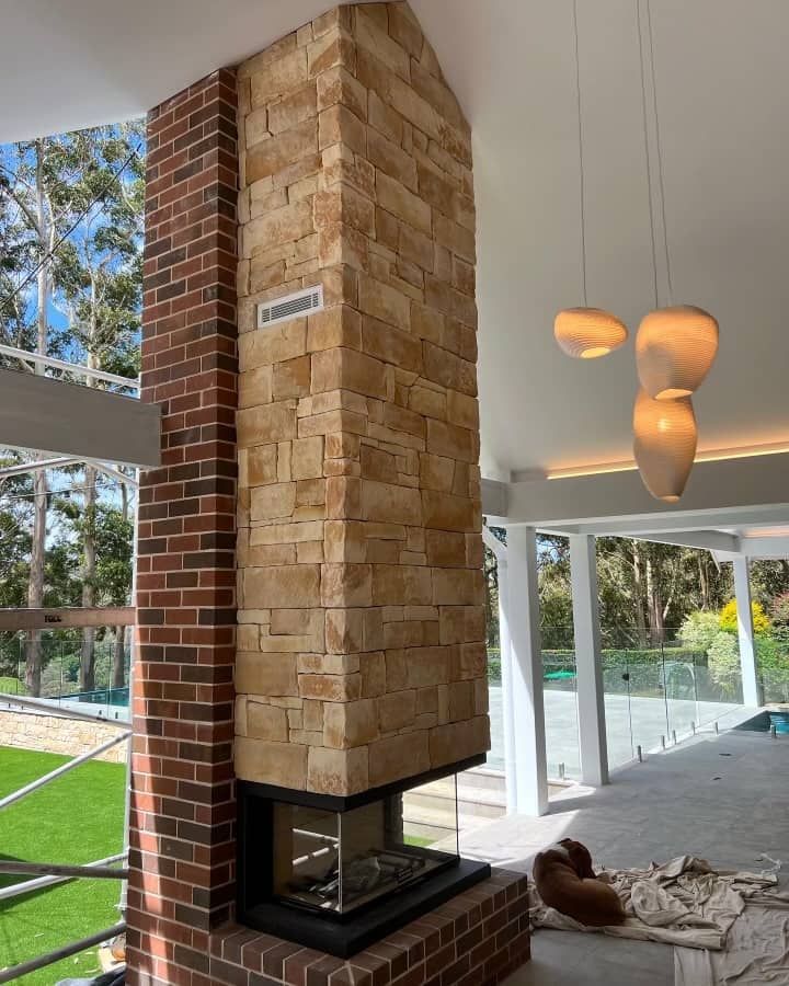A Large Brick Fireplace is in the Middle of a Living Room — ASpect Wall & Floor Tiling in Lake Macquarie, NSW