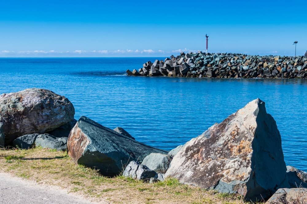 A Large Rock Sitting On The Shore Of A Body Of Water — ASpect Wall & Floor Tiling in Forster, NSW