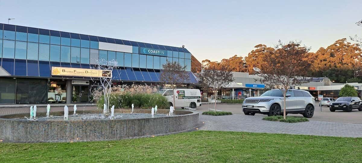 A Car is Parked in Front of a Building Next to a Fountain — ASpect Wall & Floor Tiling in Erina, NSW