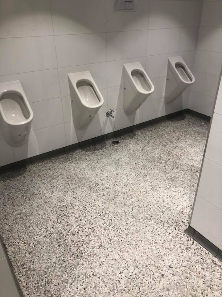 A Bathroom With Urinals on the Wall and a Tiled Floor — ASpect Wall & Floor Tiling in Wyong, NSW