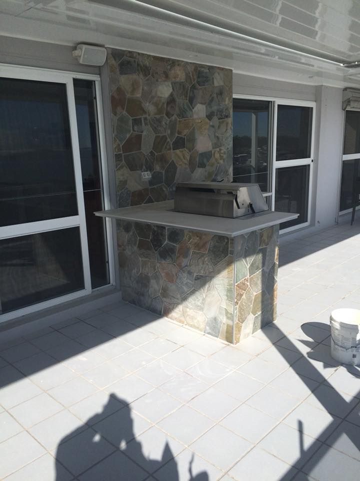 A Patio With a Grill and a Bucket on It — ASpect Wall & Floor Tiling in Woy Woy, NSW