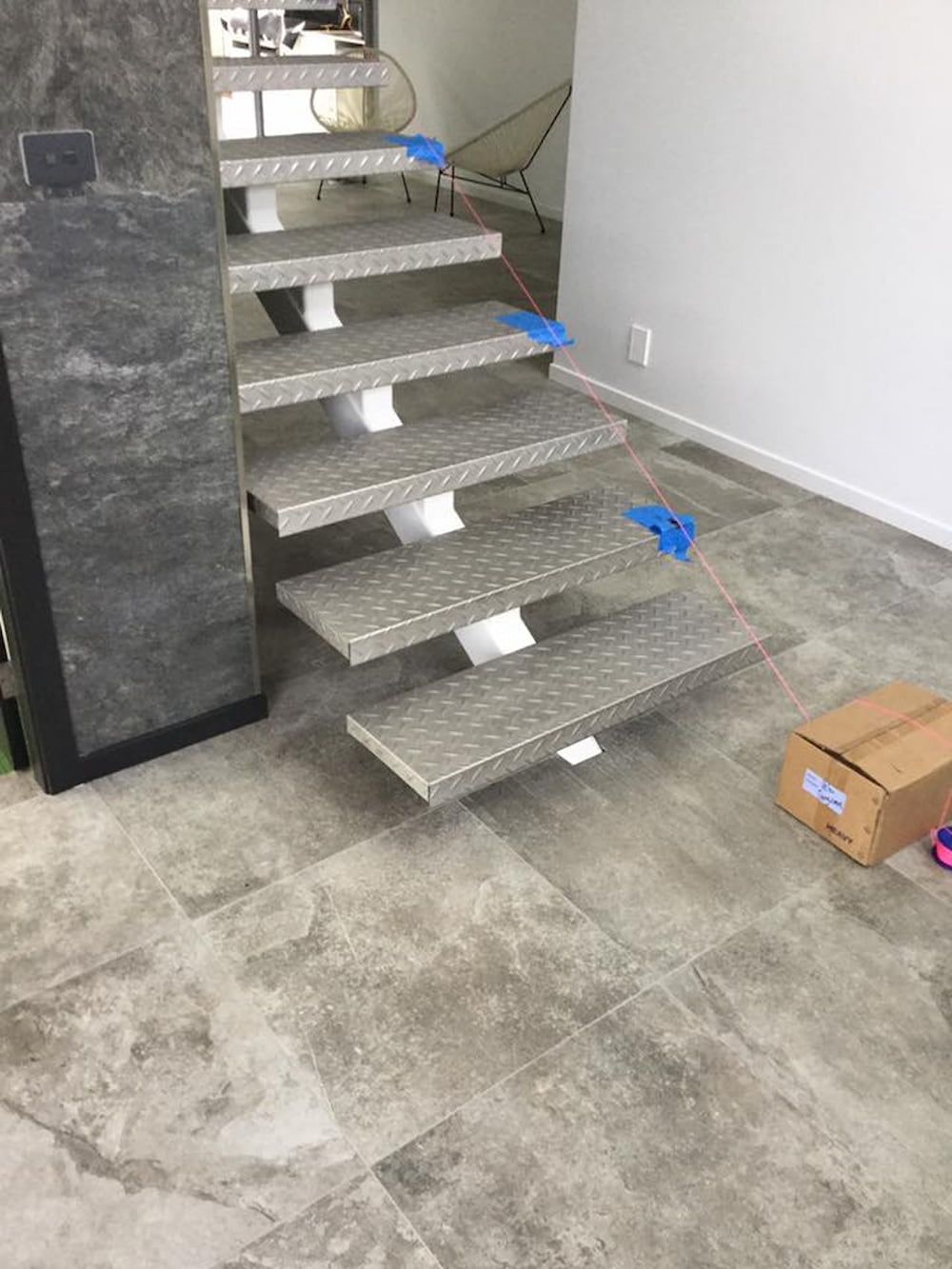 A Staircase Is Being Built In A Room With A Box On The Floor — ASpect Wall & Floor Tiling in Taree, NSW
