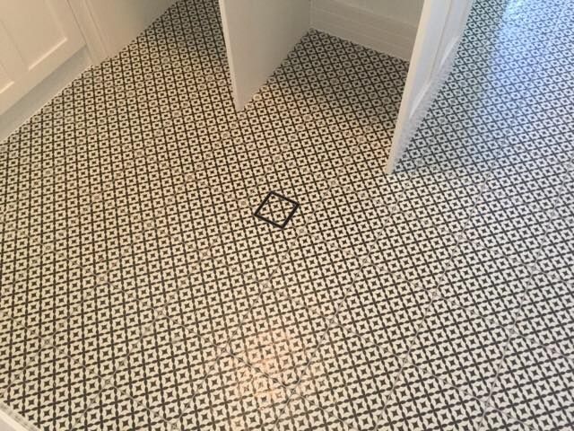 A Black and White Tile Floor in a Bathroom With a Drain — ASpect Wall & Floor Tiling in Erina, NSW