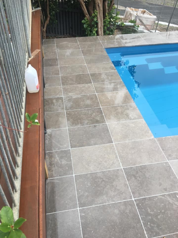 A Gallon of Milk Sits on a Ledge Next to a Swimming Pool — ASpect Wall & Floor Tiling in Sydney, NSW