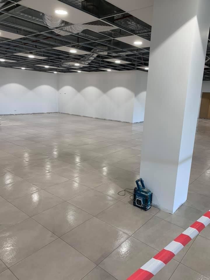 A Large Empty Room With a Red and White Tape on the Floor — ASpect Wall & Floor Tiling in Forster, NSW