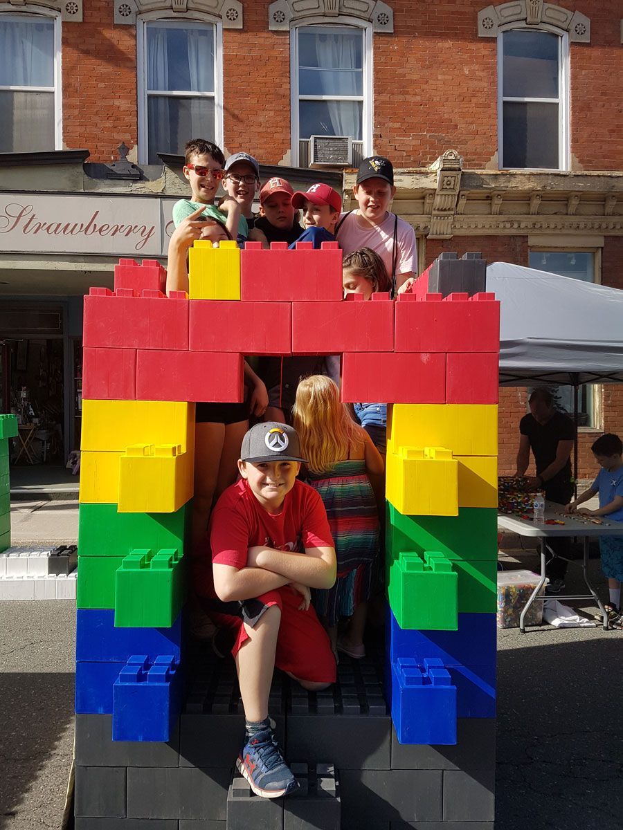A group of people are sitting in a giant lego castle