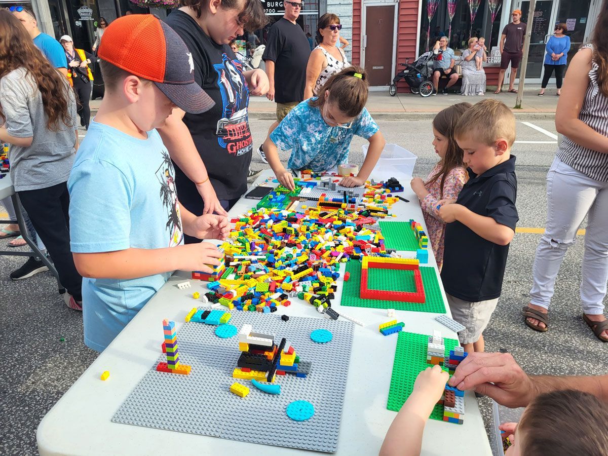 A group of children are playing with lego blocks at a table.