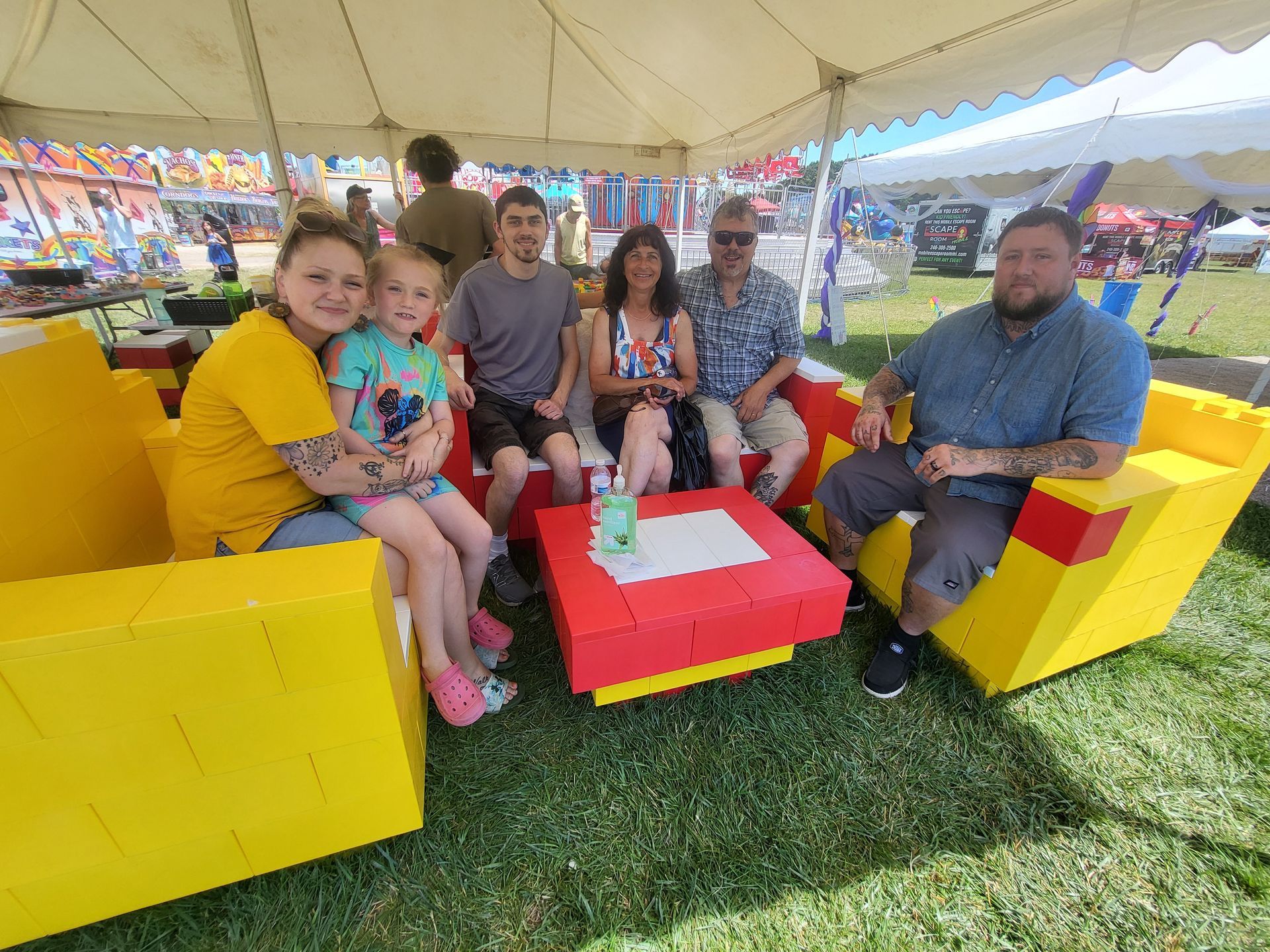 A group of children are posing for a picture in front of bowling pins.